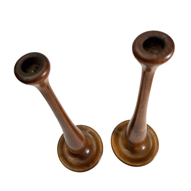 This is a pair of turned teak wood candlesticks represents a traditional craft technique dating from the early to mid-20th...