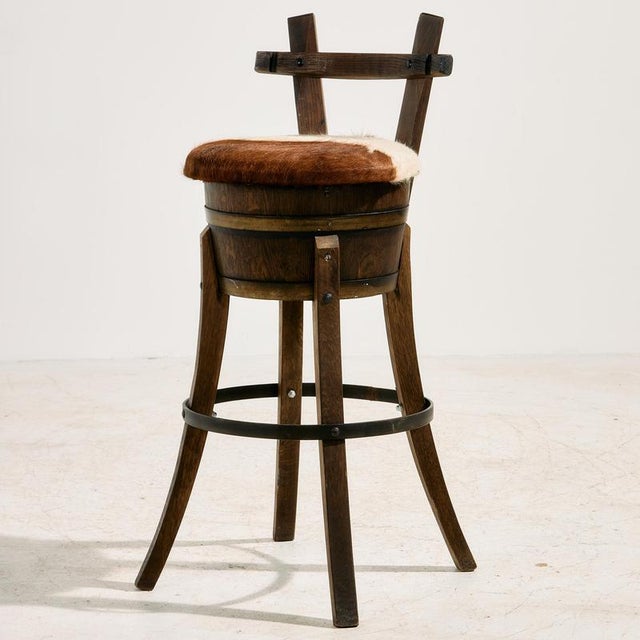 Beech bar stool made from a barrel with cowhide upholstery from the 1970s. with some surface scratches, stains and wear on...