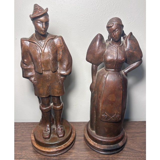 Up for sale is a Set of 2 Early 20th Century French Bronze-Clad Plaster Breton Man and Woman Sculptures on Wood Bases! The...