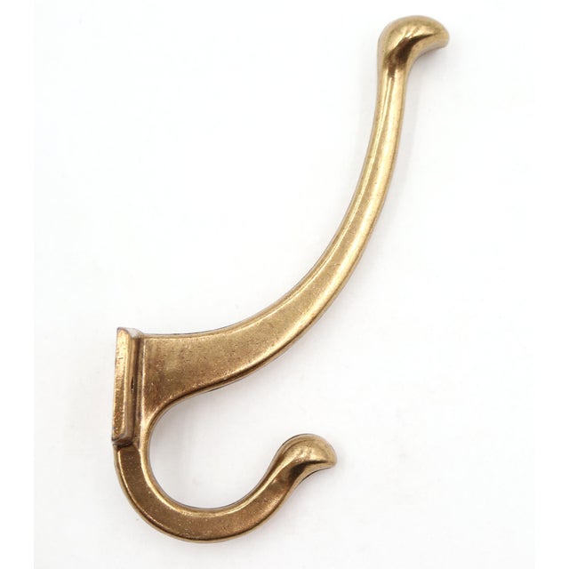 Newly made polished brass wall hook featuring a curved gooseneck body and ball shaped end. Stamped 42239 KBC. Mounting...