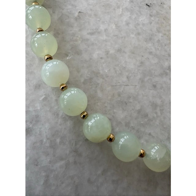 Lovely vintage light green jade beads have been carefully strung and finished with a designer gold tone clasp by Matthew...