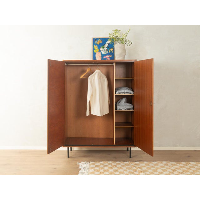 Classic wardrobe from the 1960s. Walnut veneer frame with two doors, four shelves, a clothes rail, and new black square...