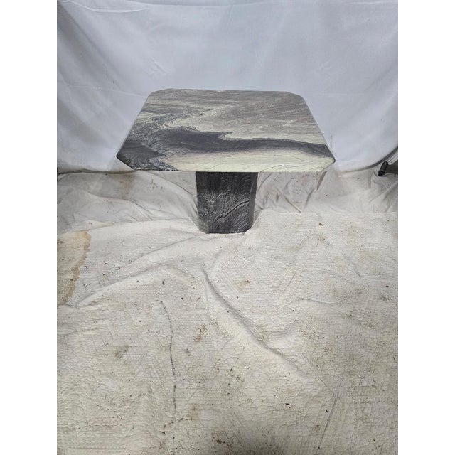 Contemporary natural stone pedestal accent table featuring a polished square top with clipped corners and striking gray,...