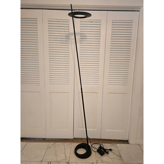 A vintage minimalistic floor lamp mid century modern inspired in a sleek black patina. Having a floating style UFO halo...