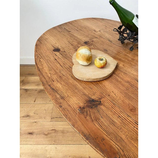 Large enough for dining, this Oval shaped 19th century vendange table features a hand carved pine top on an oak base and...