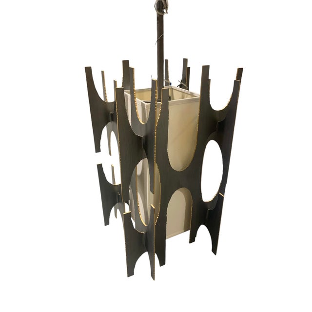 Contemporary Brutalist style iron and linen eight-candle pendant lamp. The iron components have a graphite finish with...