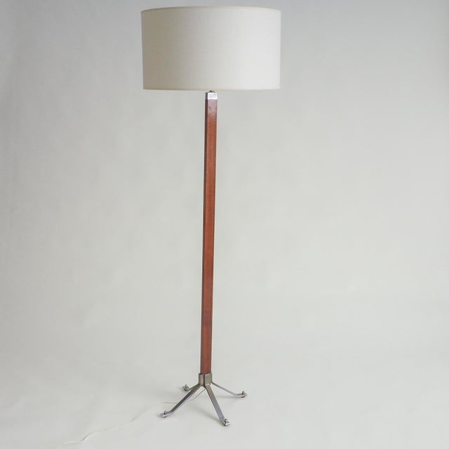This elegant vintage floor lamp embodies a timeless mid-century aesthetic. The tall, slender stand, crafted from a warm-...