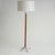 This elegant vintage floor lamp embodies a timeless mid-century aesthetic. The tall, slender stand, crafted from a warm-...