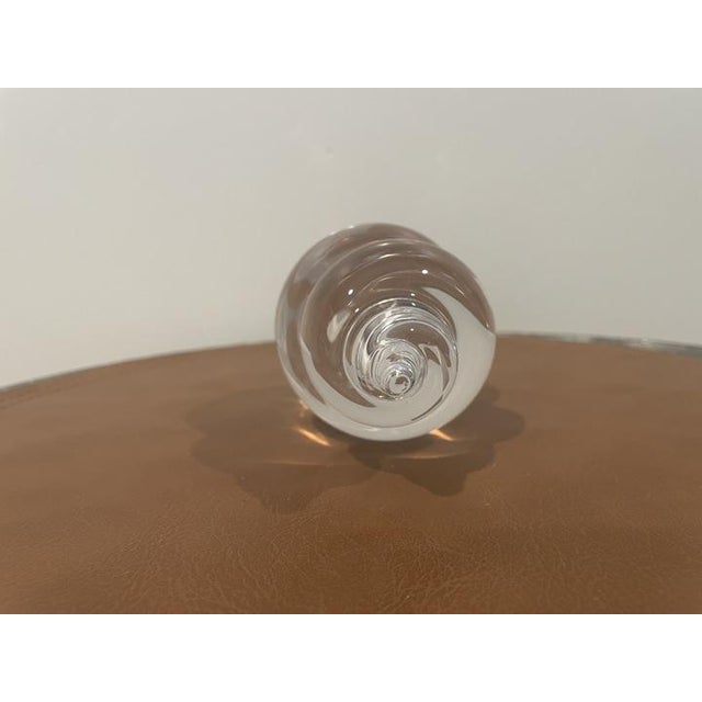 Elegant crystal art glass paperweight with a polished sculptural form. The piece appears to be signed on the base,...