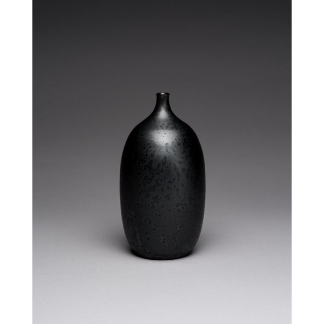 Small studio pottery vase made by Karin and Walther Zander in Germany in 1977. The rounded bottle form is finished in a...
