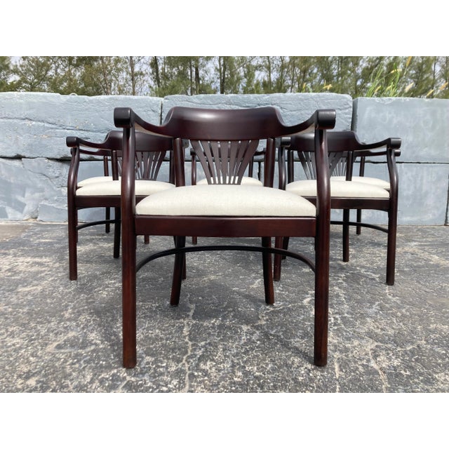 Set of four Bentwood Arm Dining Chairs In the style of Thonet. Seats have been recently reupholstered, wood has a dark...