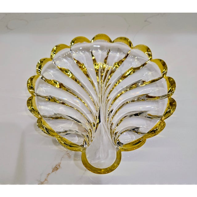 Elevate any vignette with this luminous crystal shell dish, elegantly finished with a rich gold rim that catches the light...