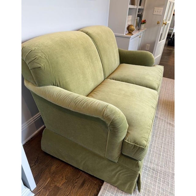Adorable two seat sofa in a happy grass green velvet. Sofa features rolled back and arms, and a flat front skirt. Fabric...