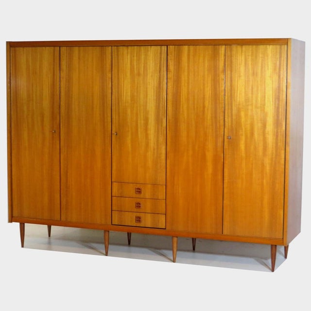 Large vintage 5-door teak wardrobe from the 1960s. This mid century wardrobe rests on eight stylish conical legs of solid...