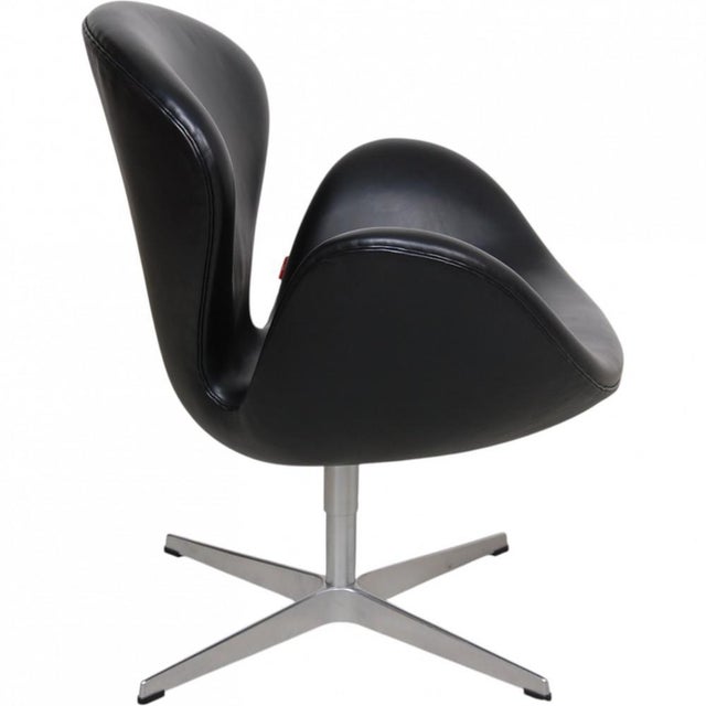 Arne Jacobsen Swan chair upholstered with original black Aura leather from Fritz Hansen. The chair is from 2006 and...