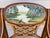 A striking vintage Italian Regency armchair featuring an oval hand-painted landscape medallion, gilt accents, and elegant...