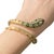 14K yellow gold snake bracelet, featuring intricate enamel detailing in green and blue swirls. The head is adorned with...