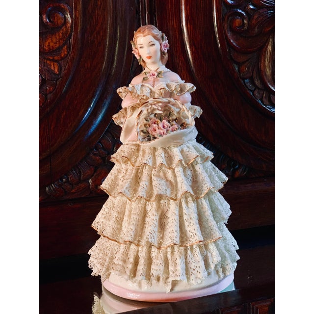 Vintage Lee Wollard porcelain figurine of a young woman wearing an off-white lace dress over a light pink bodice holding a...