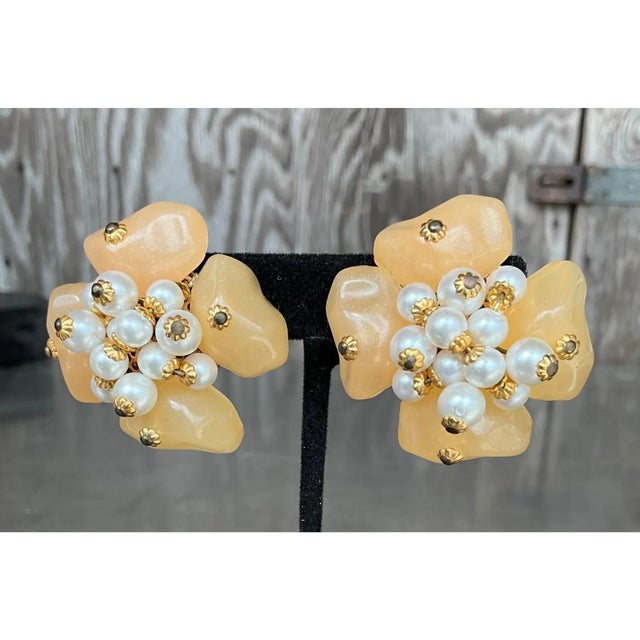 These vintage clip-on earrings are sculpted as full, four-petal blossoms, each petal a soft, irregular lobe that swells...