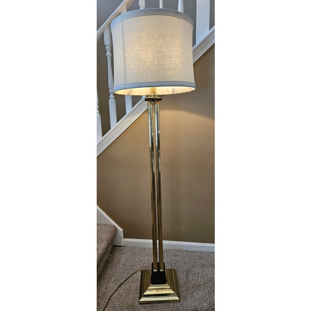 Classic brass floor lamp. Gleaming brass finish. Included is a lovely ivory Shade. Overall height is 62" Base to bottom of...