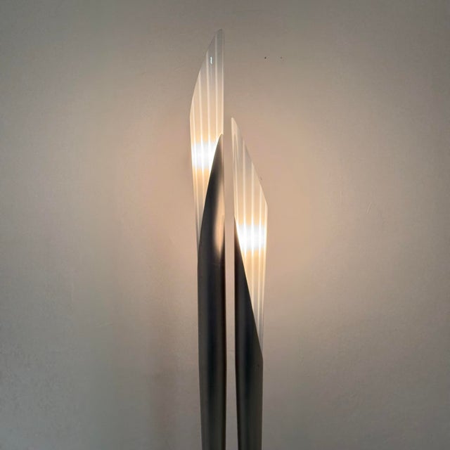 A stunning floor lamp with a modern and vintage design, featuring a sculptural structure with an asymmetrical double stem...