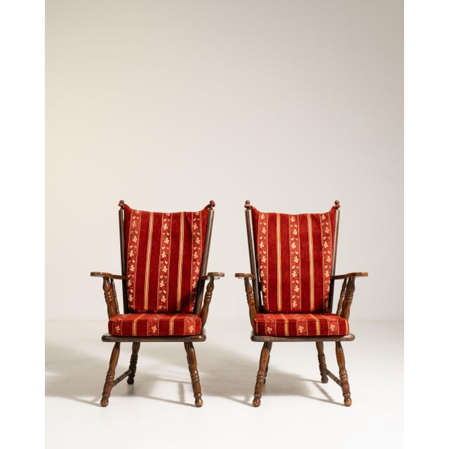 A pair of oak-framed armchairs with upholstered seating, blending Dutch design influence with mid-century simplicity. The...