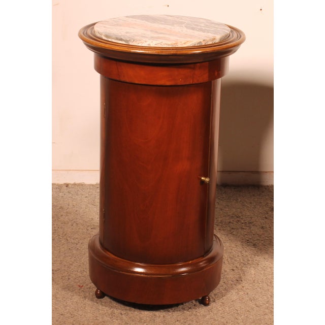 Exquisite pair of Empire-style mahogany bedside tables or end tables A pair of cylindrical tables with a door opening The...