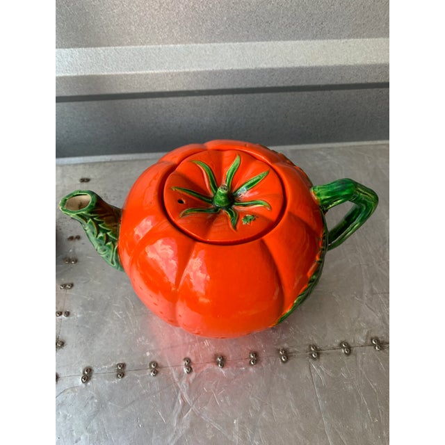 A cute little tea pot perfect for the tomato lover! Is ceramic and painted a vibrant orange/red and green.