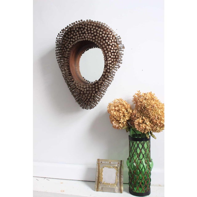 This is an antique folk art mirror, having several nails that the artist pounded into the wood frame. The nails have a...
