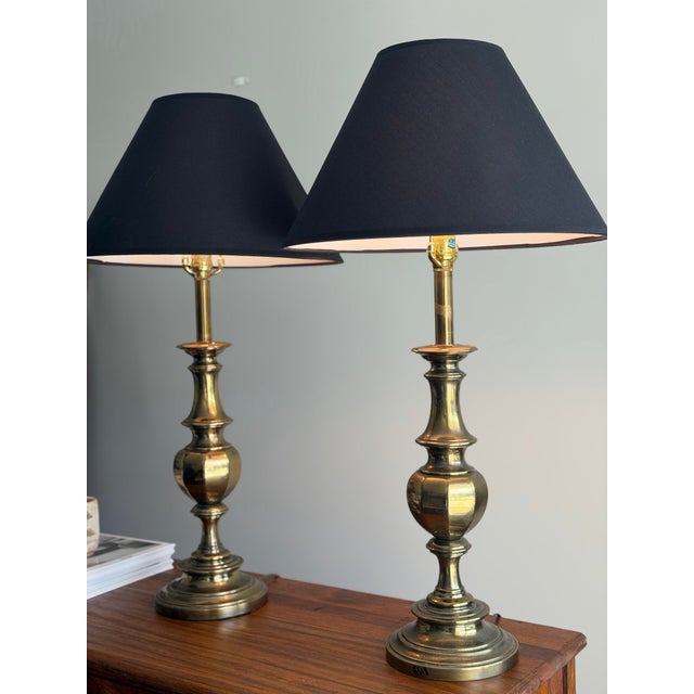A stately matched pair of vintage Stiffel brass table lamps with sculptural baluster-form bodies, stepped circular bases,...