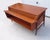 Impressive vintage teak desk in a teak finish. Offset, slanted top with storage: 1 large drawer on the left, 2 drawers on...