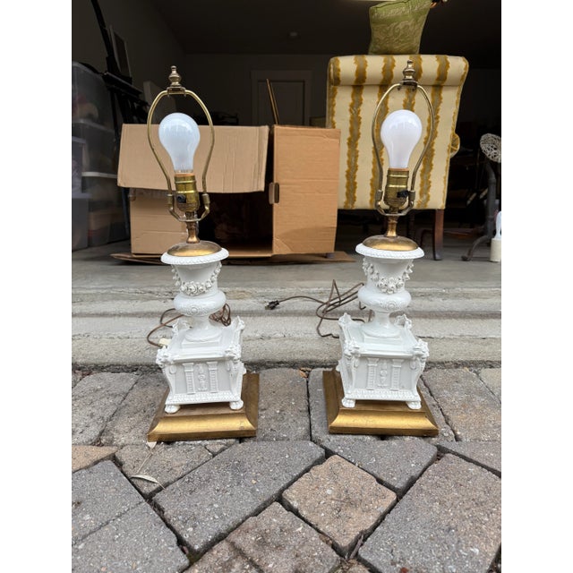 Beautiful lamps in white porcelain featuring floral bouquet detailing and a painted gold base. English smocked pleat...