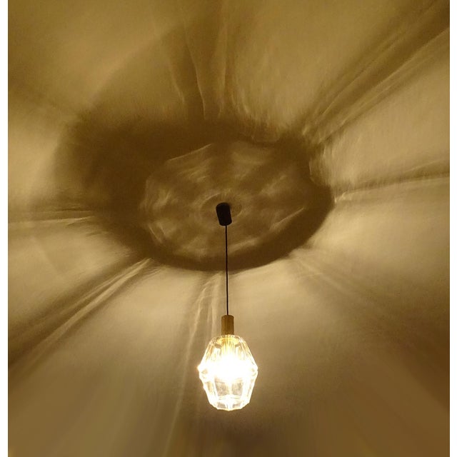 Large pendant light by limburg, featuring an oversized polyhedral glass shade with highlighted edge, polished brass...