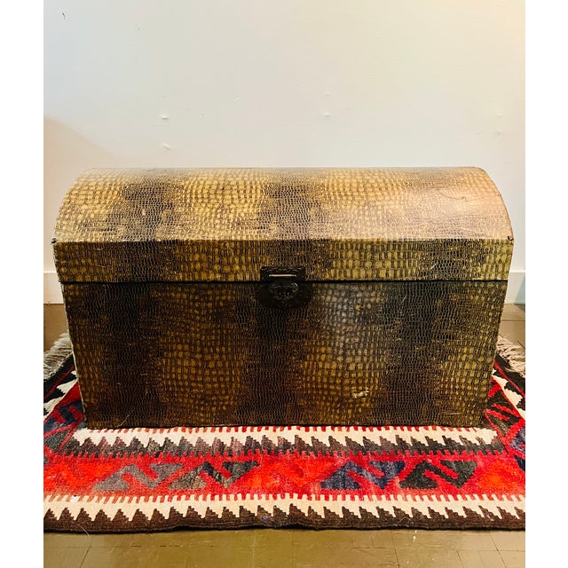 Stylish storage trunk with a faux alligator/crocodile wrap finish. Measures approximately 25.5" x 15" x 15.75" tall. Brass...