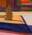 This oil on canvas artwork captures a vibrant winter scene, where abstracted forms of trees and buildings emerge in bold...