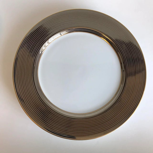 Fitz and Floyd "Les Bandes Platinées" dinner plates of white porcelain with delicate bands of reflective platinum gray on...
