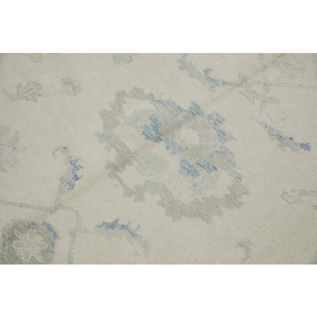 This modern Turkish Oushak rug is a stunning piece of art that has been handwoven using traditional techniques by skilled...