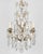 An early 20th century French Louis XV style six-light chandelier with an assortment of crystal prisms and pendalogues with...