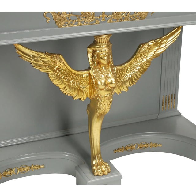 Elegant and theatrical, this pair of Neoclassical Empire console tables captures the enduring appeal of French Empire...