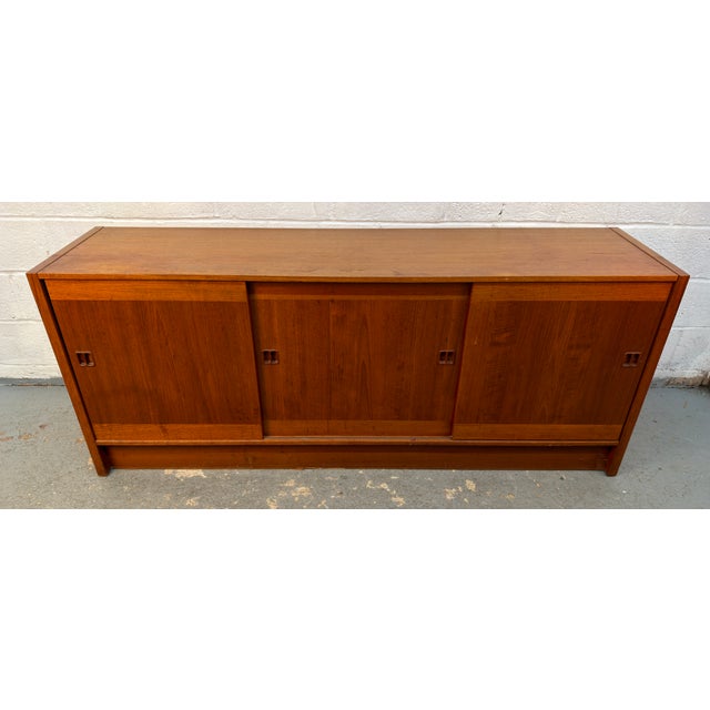 A beautifully crafted vintage Danish teak credenza showcasing the timeless elegance of Scandinavian mid-century design....