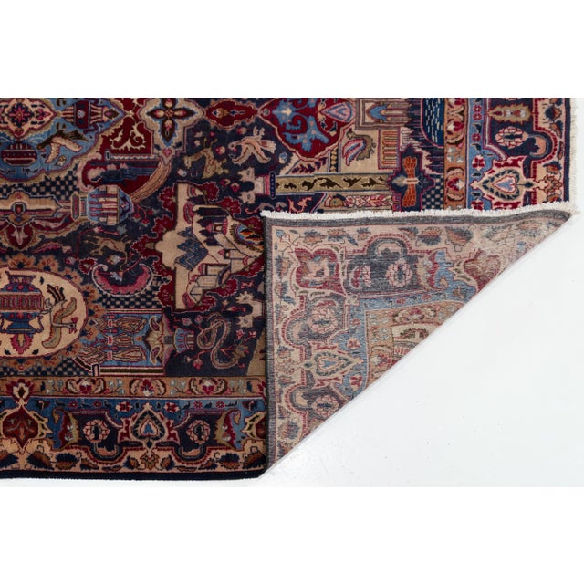 This Handmade Persian Kashmar wool rug features a navy blue field with multicolored accents throughout the design. This...