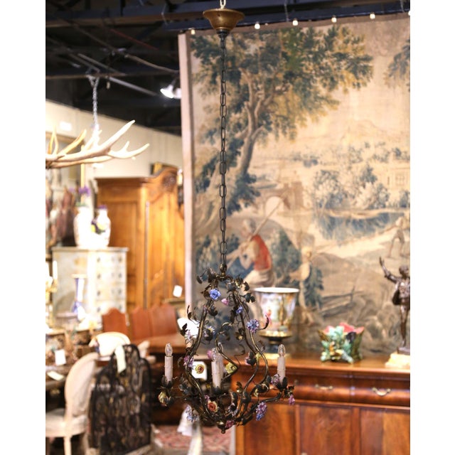 Graceful and highly decorative, this antique floral chandelier combines delicate porcelain blossoms with an airy scrolling...