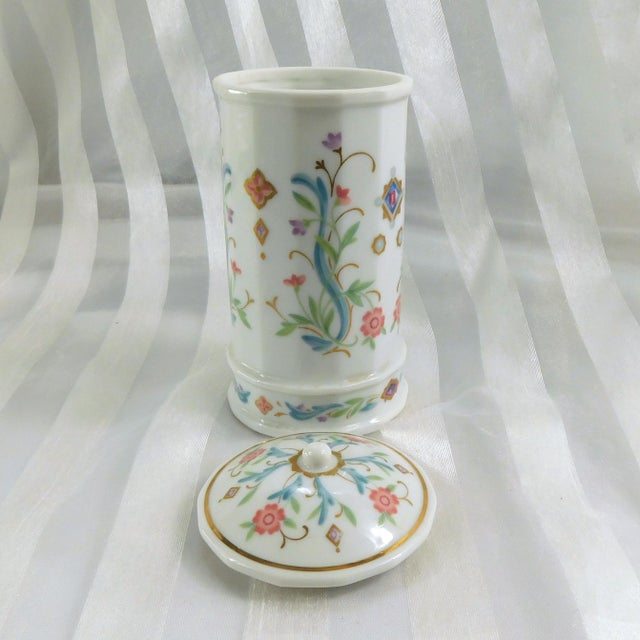 This ia a tall white covered container with a multicolor floral design by Prestige Place in the Venetian pattern. It could...