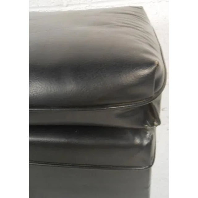 Two comfortable vintage-modern black vinyl ottomans. (Please confirm item location - NY or NJ - with dealer) Seller:...