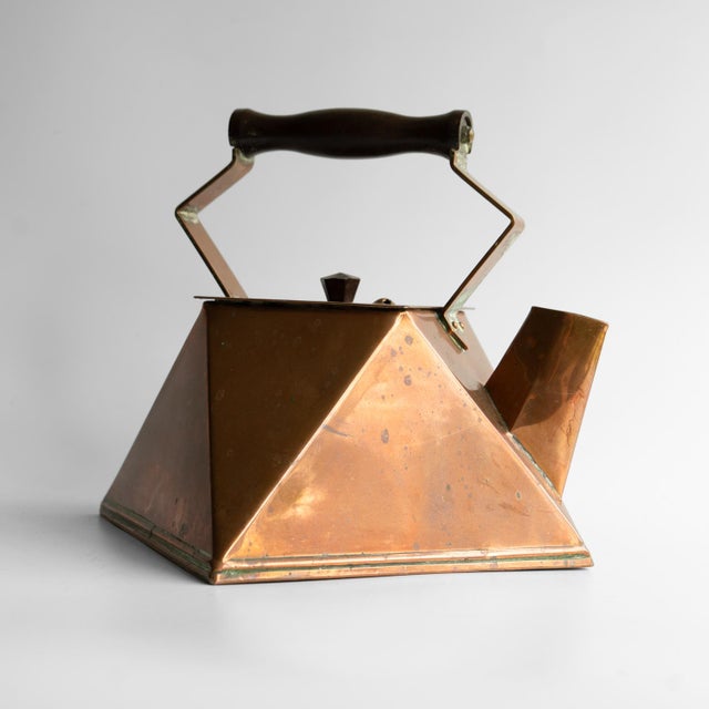 ANTIQUE COPPER KETTLE Casting an angular silhouette with triangular and diamond shapes throughout in the modernist taste....