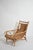 Rattan low armchair, 1950s. Rattan and bamboo low lounge armchair with a woven seat and back, curved scroll details on the...