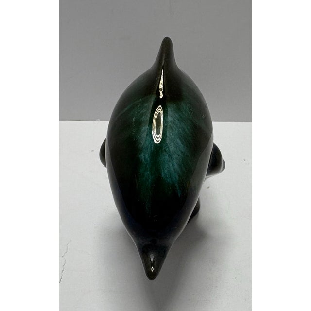 This is a vintage glazed ceramic dolphin sculpture with a rich emerald-green and teal high-gloss finish. The stylized form...