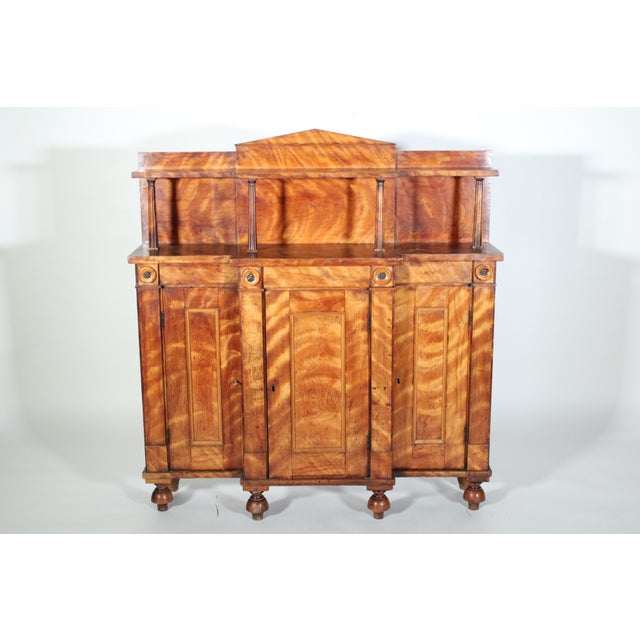 Neo classical style maple chiffonier / cabinet, early 19th century. With a Palladiam style pediment, a top shelf supported...