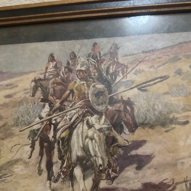A compelling vintage Western art print capturing a dramatic historical narrative of Native American warriors traversing a...