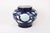 This blue glazed jar with a prominenetly featured white flower features a band of arabesque leaves and vines that wrap...